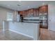 Modern kitchen featuring stainless steel appliances, dark wood cabinets, and a large island with black countertops at 34107 Alameda Dr, Sorrento, FL 32776
