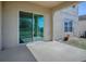 Covered concrete patio with a sliding glass door and partial views of the backyard and the home's exterior at 34107 Alameda Dr, Sorrento, FL 32776