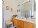 Bright bathroom with wood vanity featuring double sinks and a large vanity mirror with lighting at 3440 Tumbling River Dr, Clermont, FL 34711