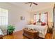 The sun-filled bedroom boasts wood floors, a ceiling fan, and comfortable bed with a chest at 3440 Tumbling River Dr, Clermont, FL 34711