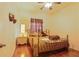 Cozy bedroom features wood floors, ceiling fan, and a comfortable iron frame bed at 3440 Tumbling River Dr, Clermont, FL 34711