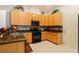 Kitchen featuring wood cabinets, stainless steel appliances, tiled backsplash, and tiled floor at 3440 Tumbling River Dr, Clermont, FL 34711