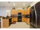 Spacious kitchen with stainless steel refrigerator, gas range, tiled backsplash, and tiled floor at 3440 Tumbling River Dr, Clermont, FL 34711
