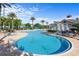 Beautiful community pool with inviting lounge chairs and well-manicured tropical landscaping at 3440 Tumbling River Dr, Clermont, FL 34711
