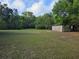 Expansive backyard with lush grass and a storage shed provides ample space and storage at 350 Cassady St, Umatilla, FL 32784