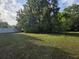 Large grassy yard with mature trees and white fence, perfect for Gathering gatherings and activities at 350 Cassady St, Umatilla, FL 32784
