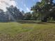 Lush green lawn surrounded by mature trees, offering privacy and a serene atmosphere at 350 Cassady St, Umatilla, FL 32784
