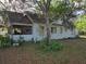 Rear view of a charming home featuring a screened porch and lush, mature landscaping at 350 Cassady St, Umatilla, FL 32784