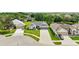 Aerial view of the gray roof home on a corner lot with a well-manicured lawn and a two car garage at 3800 Woodleaf Ct, Leesburg, FL 34748