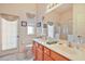 Bathroom featuring a double vanity, toilet, framed mirror, and walk-in shower at 3800 Woodleaf Ct, Leesburg, FL 34748