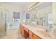 Bathroom featuring double sinks, a vanity, walk-in shower, and bathtub at 3800 Woodleaf Ct, Leesburg, FL 34748