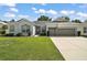 Charming single-story home with a well-manicured lawn, two-car garage, and welcoming facade at 3800 Woodleaf Ct, Leesburg, FL 34748