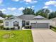Charming single-story home with a well-manicured lawn, two-car garage, and welcoming facade at 3800 Woodleaf Ct, Leesburg, FL 34748