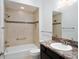 Bright bathroom featuring a tub with tan tiled walls, a dark vanity with marble countertop, and a well-lit mirror at 3942 Zenith Loop, The Villages, FL 32163