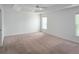 A well-lit bedroom features neutral carpeting, a tray ceiling with fan, and ample natural light at 3942 Zenith Loop, The Villages, FL 32163