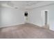 Bright bedroom with neutral carpet, tray ceiling with fan, and access to kitchen and bath at 3942 Zenith Loop, The Villages, FL 32163