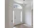 Bright entryway featuring a white front door with sidelights and decorative light fixture at 3942 Zenith Loop, The Villages, FL 32163
