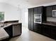 Kitchen with dark cabinets, stainless steel appliances, and stone countertops at 3942 Zenith Loop, The Villages, FL 32163