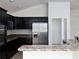 Modern kitchen with dark cabinets, stainless steel appliances, and ample counter space at 3942 Zenith Loop, The Villages, FL 32163