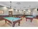 Billiards room with three pool tables, overhead lighting, and comfortable seating for leisure and entertainment at 4247 James River Cir, Leesburg, FL 34748