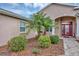 Welcoming front entrance with a vibrant red door, complemented by decorative landscaping and manicured shrubbery at 4247 James River Cir, Leesburg, FL 34748