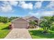 Charming home featuring a well-maintained lawn, mature palm trees, and a brick driveway, enhancing its curb appeal at 4247 James River Cir, Leesburg, FL 34748