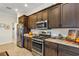 Close up of stainless steel appliances and dark wood cabinetry with granite countertops at 4247 James River Cir, Leesburg, FL 34748