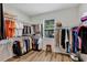Spacious walk-in closet with custom shelving, a window for natural light, and wood-look floors at 4247 James River Cir, Leesburg, FL 34748
