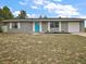 Charming single-story home featuring a vibrant blue front door, complemented by well-manicured landscaping and an attached garage at 425 Marion Oaks Dr, Ocala, FL 34473