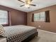 Bedroom with a black platform bed, complemented by dark brown walls and natural light from two windows at 4251 Magnolia Ave, Leesburg, FL 34748