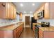 Traditional style galley kitchen showcases stainless appliances, granite countertops, and warm wood cabinets at 4251 Magnolia Ave, Leesburg, FL 34748
