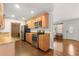 Galley kitchen features wood floors, warm cabinets, and stainless steel appliances, including a microwave at 4251 Magnolia Ave, Leesburg, FL 34748