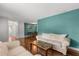 Open-concept living room features wood floors, a comfortable white sofa, and calming teal accent wall at 4251 Magnolia Ave, Leesburg, FL 34748