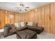 Wood paneled living room with a plush sectional couch, perfect for relaxation at 4251 Magnolia Ave, Leesburg, FL 34748