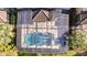 Overhead view of screen-enclosed pool and patio area, bordered by manicured shrubs and mature trees at 4328 Acorn Ct, Davenport, FL 33837