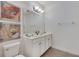 Bathroom featuring a dual sink vanity with framed floral artwork adding a touch of elegance at 4328 Acorn Ct, Davenport, FL 33837