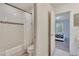 Bright bathroom featuring a bathtub with a shower curtain, a toilet, and access to a bedroom at 4328 Acorn Ct, Davenport, FL 33837
