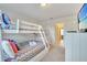 Bright bedroom showcasing a bunk bed, colourful bedding, storage, and a view into another room at 4328 Acorn Ct, Davenport, FL 33837