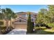 Charming two-story home showcasing a well-manicured lawn, mature trees, and a spacious two-car garage at 4328 Acorn Ct, Davenport, FL 33837
