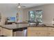 Open-concept kitchen with stainless steel dishwasher and view to the living area and a screened-in patio beyond at 4328 Acorn Ct, Davenport, FL 33837