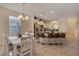 Bright kitchen and dining area featuring white cabinetry, an island with seating, and modern chandelier at 4328 Acorn Ct, Davenport, FL 33837