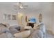 Bright living room features a comfortable gray sectional sofa, ceiling fan, and tiled floors, creating a welcoming atmosphere at 4328 Acorn Ct, Davenport, FL 33837