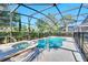 Enclosed pool and spa area with a screened enclosure and lush landscaping at 4328 Acorn Ct, Davenport, FL 33837