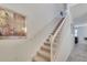 Carpeted staircase with white railings, artwork, and leading to the upper level at 4328 Acorn Ct, Davenport, FL 33837