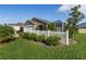 Attractive home exterior with a screened lanai, neatly kept landscaping, and white picket fence at 463 Kayla Ct, The Villages, FL 32163