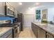 Kitchen boasts stainless steel appliances, gray cabinets, and granite countertops with a pantry at 463 Kayla Ct, The Villages, FL 32163