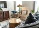 Comfortable living room featuring a stylish chair, a decorative lamp, and a cozy sofa with plush pillows at 463 Kayla Ct, The Villages, FL 32163