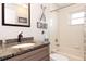 Updated bathroom featuring granite vanity, decorative accents, and tiled shower at 4723 Saint Andrews Arc, Leesburg, FL 34748