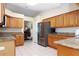 Well-lit kitchen featuring oak cabinets, tile floors, stainless steel appliances and granite countertops at 4723 Saint Andrews Arc, Leesburg, FL 34748