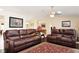 Spacious living room featuring comfortable leather furniture and an accent rug, with a view into the dining area at 4723 Saint Andrews Arc, Leesburg, FL 34748